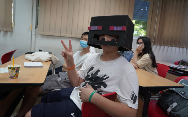 SLE student posing wearing a halloween themed box on his head.